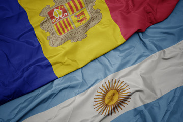 waving colorful flag of argentina and national flag of andorra.