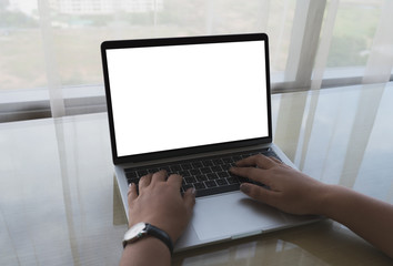 Close-up image of a business woman's hands are using Laptop computer with blank screen on wood table, business concept. Mockup design with copy space for text, advertising and banner.
