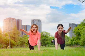 Obraz premium young asian women doing gesture of exercise yoga training in city public park