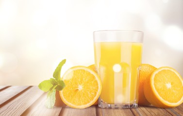 Orange juice and slices of orange on wooden table