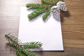 Fototapeta premium empty paper with fir branches and cones on the wooden background