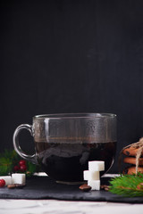 Coffee with milk preparation in glass cup on black background with coffee beans and sugar