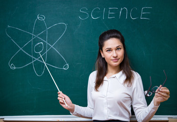young teacher explains science at blackboard