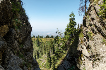 Through the crevice on the top of the mountain, trees and houses are visible