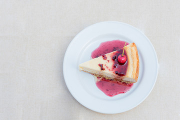 Berry cheesecake slice with Berries Sauce on white plate, tasty dessert