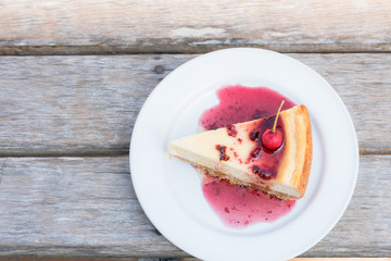 Berry cheesecake slice with Berries Sauce on white plate, tasty dessert