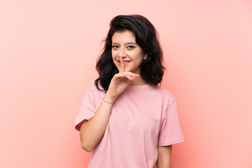 Young woman over isolated pink background doing silence gesture