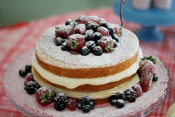 Close up of cake stuffed with cream and topped with berries