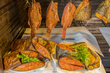 Various kinds of marine fish which hangs in a smokehouse for smoking. Concept: healthy diet or omega-3 fatty acids