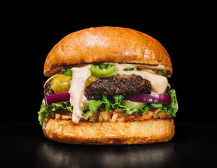 Craft burger is cooking on black background. Consist: sauce salsa, lettuce, red onion, pickle, cheese, chilli green pepper, bun, marbled meat beef. - obrazy, fototapety, plakaty