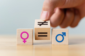 Concepts of gender equality. Hand flip wooden cube with symbol unequal change to equal sign - obrazy, fototapety, plakaty