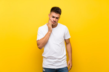Fototapeta na wymiar Young handsome man over isolated yellow background with toothache