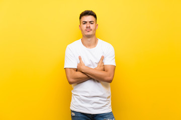 Fototapeta na wymiar Young handsome man over isolated yellow background feeling upset