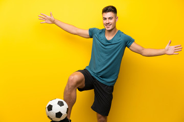 Handsome young football player man over isolated yellow background