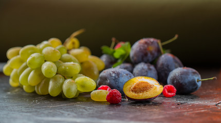 Natural grapes with natural plum on a black background.