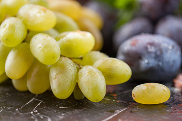 Natural grapes with natural plum on a black background.