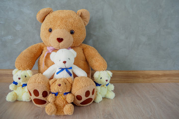 A group of teddy bears sitting on wooden floor at home. On special occasions for surprise.