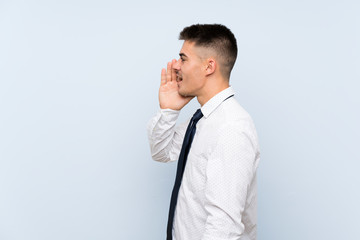 Handsome businessman over isolated blue background shouting with mouth wide open