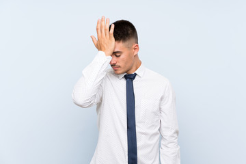 Handsome businessman over isolated blue background having doubts with confuse face expression