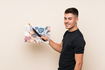 Young artist man over isolated background smiling a lot