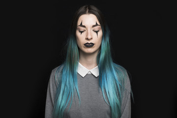 Young woman with long blue hair standing in studio