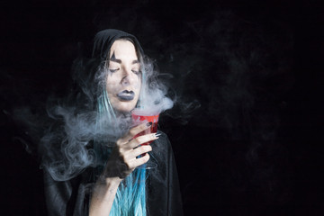 Attractive sorceress holding goblet with red smoky liquor