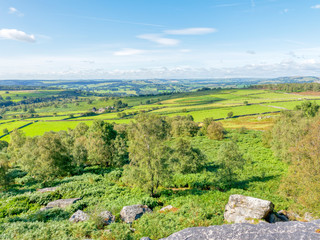 Obraz premium The Derbyshire countryside from high on Birchen Edge, a gritstone escarpment, on a bright summer day.