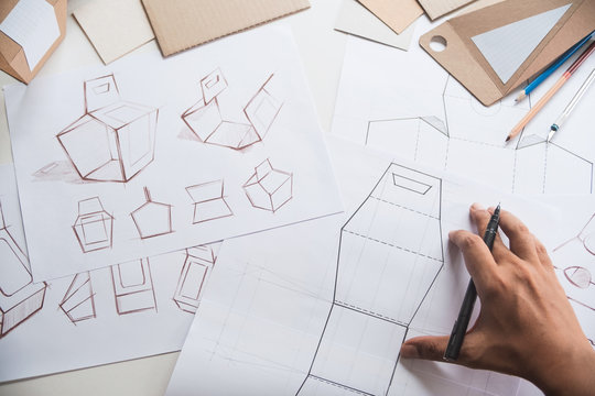 Designer sketching drawing design Brown craft cardboard paper product eco packaging mockup box development template package branding Label . designer studio concept .