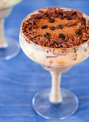 italian dessert tiramisu in an elegant cocktail glass, the concept of sweet life, luxury, delicious food