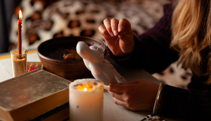 Voodoo doll in hands of witch, ritual. Psychic vision, fortune teller.
