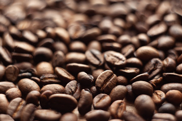 Roasted brown coffee beans, can be used as a background and texture. Coffee beans on the table background texture. Background full of coffe beans studio shoot.