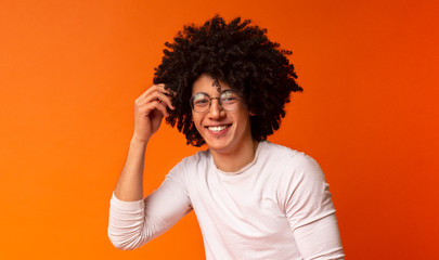 Carefree black guy in glasses with bushy hairstyle laughing