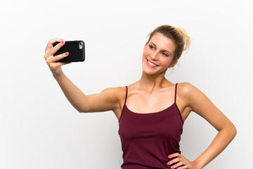 lYoung blonde woman using mobile phone and making a selfie