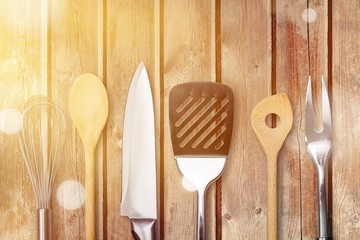 Set of modern steel kitchen utensils on wooden table