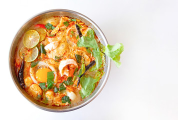 Shrimp soup or Noodle Tom Yam goong Traditional food in Thailand contains chili, lime, ginger, galangal, lemongrass, lime leaf, on a white wood background from top view.