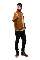 Fototapeta premium Handsome man with beard smiling and showing victory sign over isolated white background