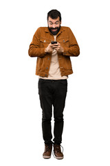 Fototapeta premium Handsome man with beard surprised and sending a message over isolated white background