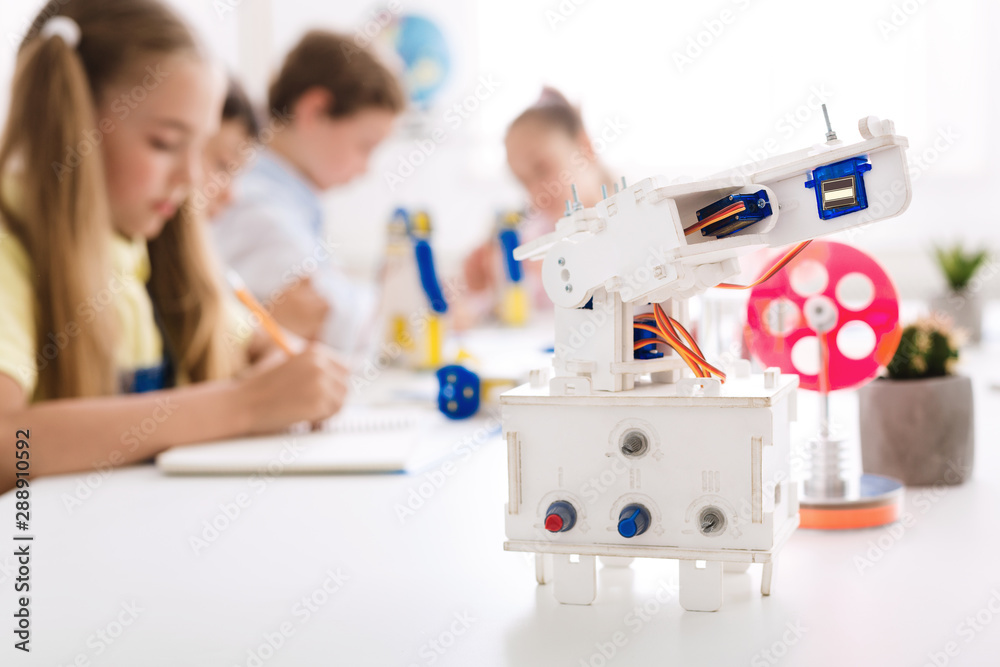 Poster robot at desk with schoolchildren at background