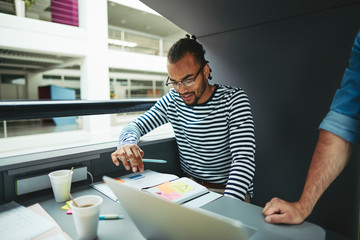 Young African American designer working in an office meeting pod