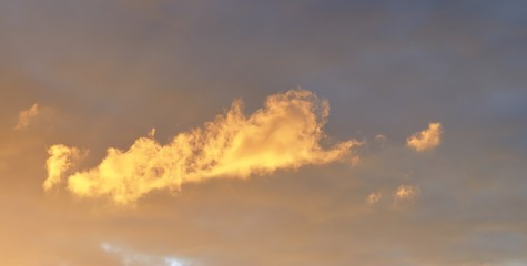 Beautiful panoramic view on orange and yellow sunset clouds in a dramatic looking sky