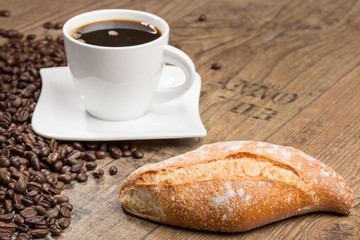 Bakery products and cup of coffee and coffee beans on a wooden table