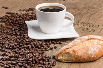Bakery products and cup of coffee and coffee beans on a wooden table