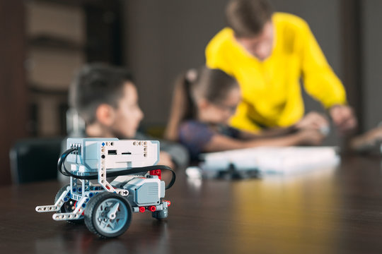 Kids creating robots with teacher. Early development, diy, innovation, modern technology concept.