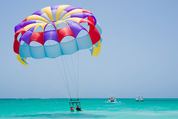 Colorful parasail wing taking off from turquoise water of Sargasso Sea, Punta Cana, Dominican...