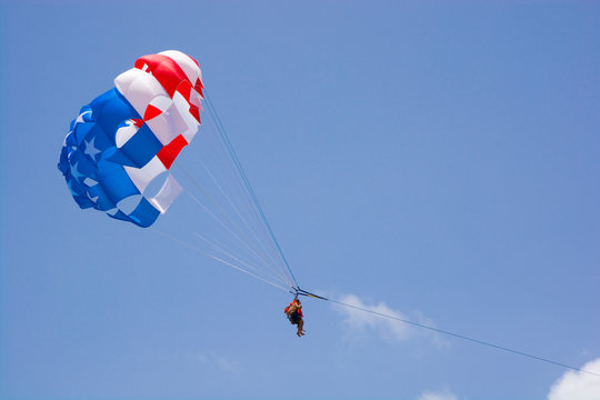 American flag colors parasail wing against cloudy blue sky, Punta Cana, Dominican Republic