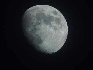 the moon is a celestial body, a satellite of the Earth, glowing with reflected sunlight.