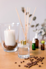 Fototapeta na wymiar decoration, home perfume and aromatherapy concept - aroma reed diffuser, burning candle and essential oil on table at home