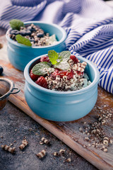 Vertical shot cottage dessert with jam in blue deep bowl, Strawberry jam and blueberries