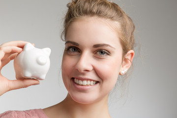 young happy girl with a piggy bank