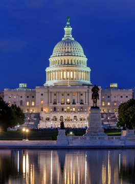 The Capitol - A dusk view of west side of U.S. Capitol Building, with Ulysses S. Grant Memorial and Reflecting Pool at front, Washington, D.C., USA. No recognizable trademark or person in the image.